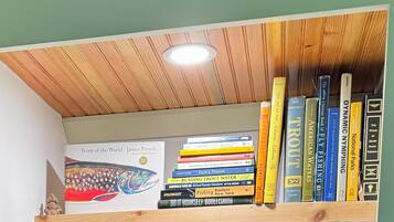 Een boekenplank met verschillende boeken, waaronder titels over vissen en forel.