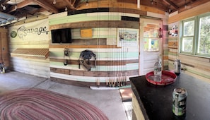 A rustic cabin interior with a wooden wall displaying a fish logo and the name 'Savage Anglers.' - Little River Cottage (Salem)