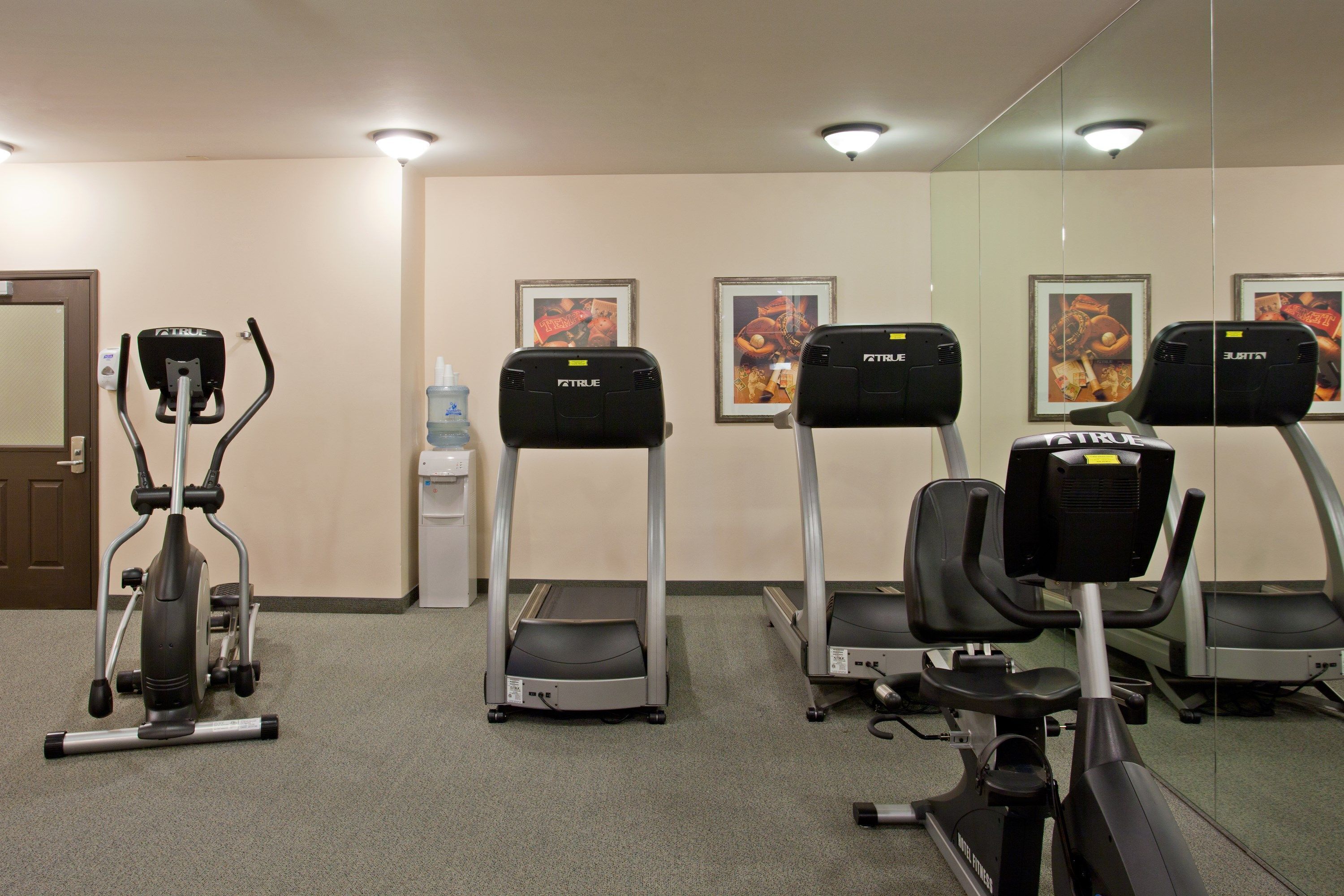 A gym with treadmills, an elliptical, and a stationary bike.