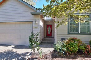 A house with a red door, a garage, and a number 2372 on the door. - Parkview Place - Wine Country Home with Jetted Tub (McMinnville)