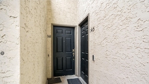 A narrow hallway with a black door marked "144" and a number "145" on the wall. - Modern 2 bedroom with 2 fire places and a 9 mile walking/biking trail (Dallas)