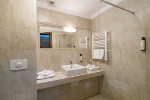 Een moderne badkamer met een grote spiegel, een wastafel en een douche.