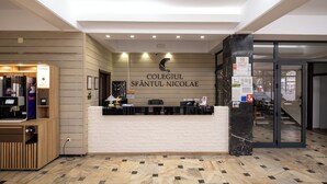 Un comptoir d ’accueil avec une pancarte indiquant « COLEGIU SFÂNTUL NICOLAE ».