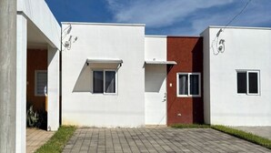 A modern residential building with a flat roof, a paved driveway, and a small front yard. - Cozy 2-bedroom house in adorable Ahuachapan with AC / pool (Ahuachapan)