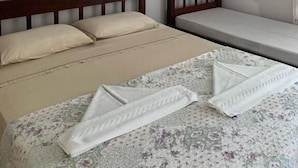 A bedroom with a large bed, a smaller bed, a nightstand, a framed picture on the wall, and an air conditioning unit. - POUSADA SOLEIL DE GENIPABU (Extremoz)