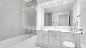 A modern bathroom with a glass-enclosed shower, a white sink, and a toilet. - Luxury 2-Bed London Apartment Greenwich & Canary Wharf (London)