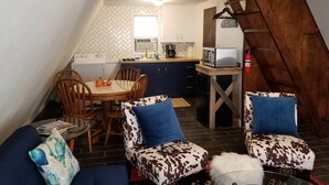 Ett mysigt och kompakt bostadsutrymme med kök, matplats och ett sovloft.