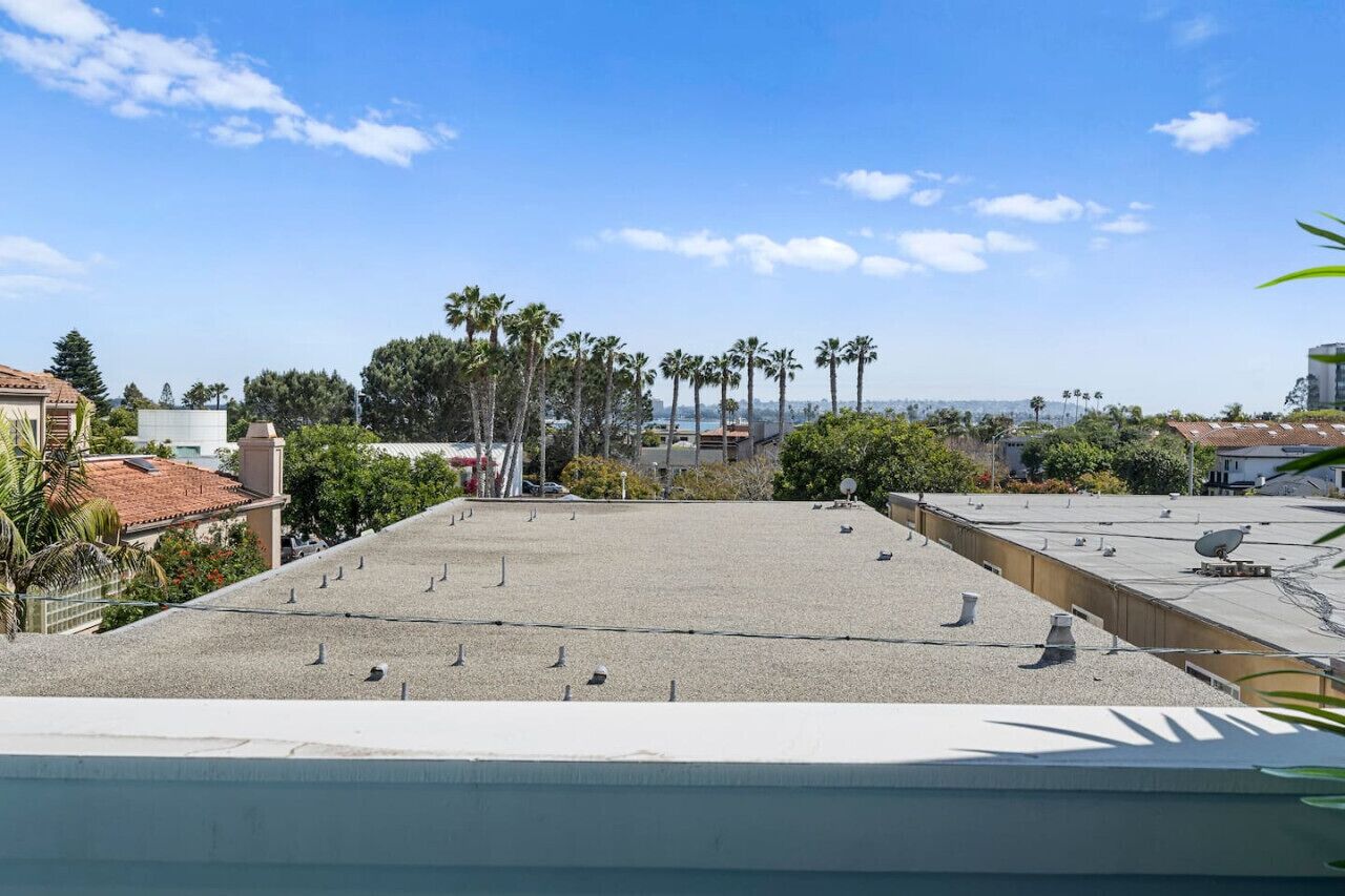 Una terrazza sul tetto con vista libera su palme e sullo skyline in lontananza.