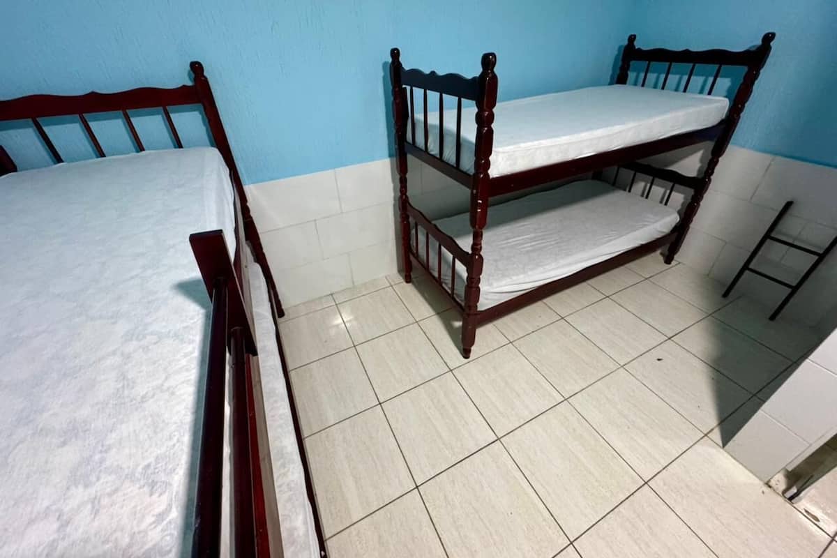 Una habitación con dos literas de madera y una pequeña escalera.