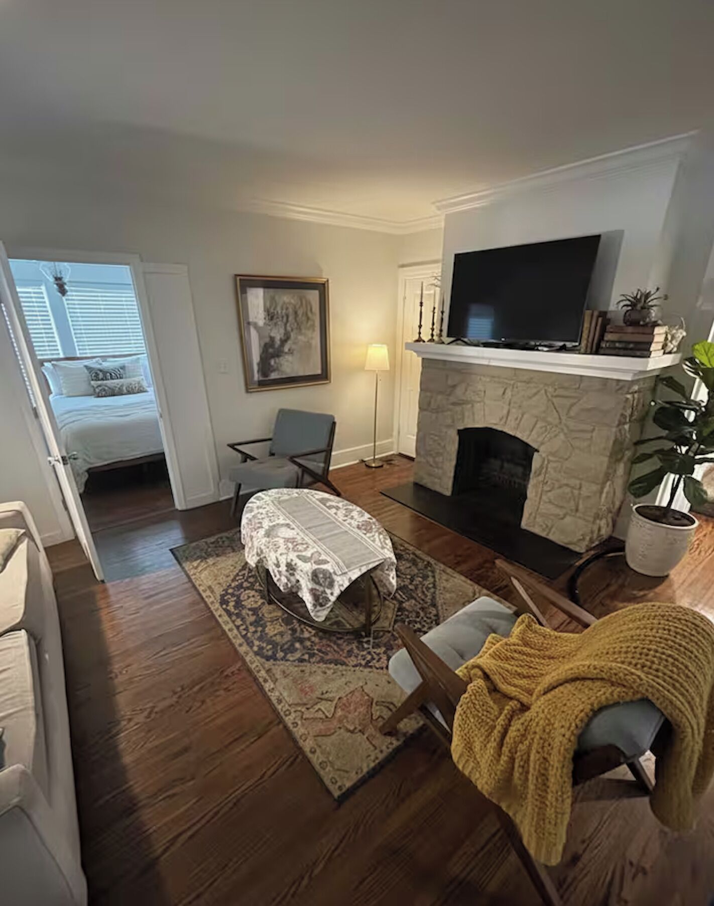 Uma sala de estar com lareira, televisão e um espaço de jantar com mesa e cadeiras.