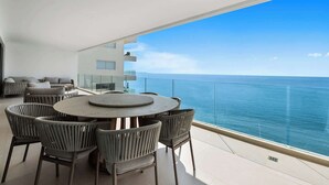 A modern balcony with a round table and chairs, overlooking a clear blue sea. - Panarea 5C | Beachfront 3BR + Panoramic Ocean View (Bucerías)