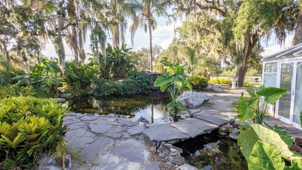 Ein Garten mit Teich, Kiesweg und verschiedenen Pflanzen.