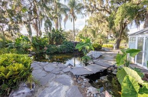 A garden with a pond, stone pathway, and various plants. - Escape to 58 Acres of Luxury — Serene Horse Estate in Orlando! (Orlando)