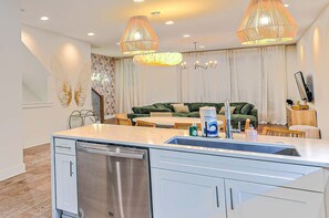 A modern kitchen with a built-in dishwasher, a dining area with a green sofa, and pendant lighting. - Rosé All Day • Insta • 21 Beds • Hot Tub/Game Room (Nashville)
