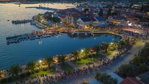 En kystby med lystbådehavn, promenade langs vandet og boligbygninger.