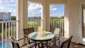 A balcony with a glass table, four chairs, and a decorative vase. - Spacious 1-bedroom 1 bath villa with full kitchen beautiful Orlando with AC (Orlando)