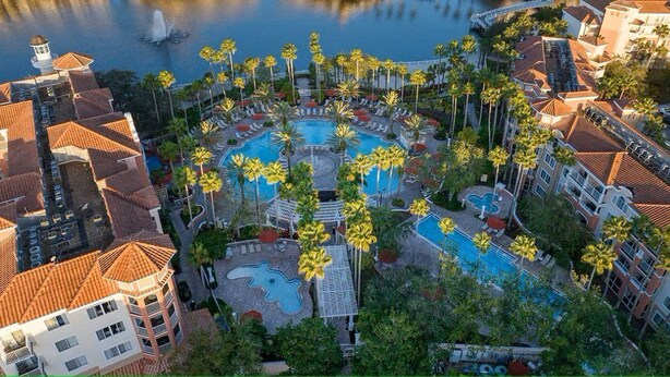 An aerial view of a resort with multiple swimming pools, palm trees, and a waterfront. - Spacious 1-bedroom 1 bath villa with full kitchen beautiful Orlando with AC (Orlando)