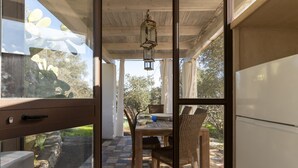 Une cuisine avec un coin repas, un réfrigérateur et une fenêtre donnant sur un jardin.