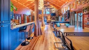 A rustic wooden interior with a bar area, seating, and a stone fireplace. - Vibrant Spacious Mountain Estate with Heated Pool & Hot Tub in Suches (Suches)