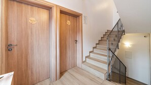 Una escalera de madera con barandilla metálica que lleva a una plataforma.