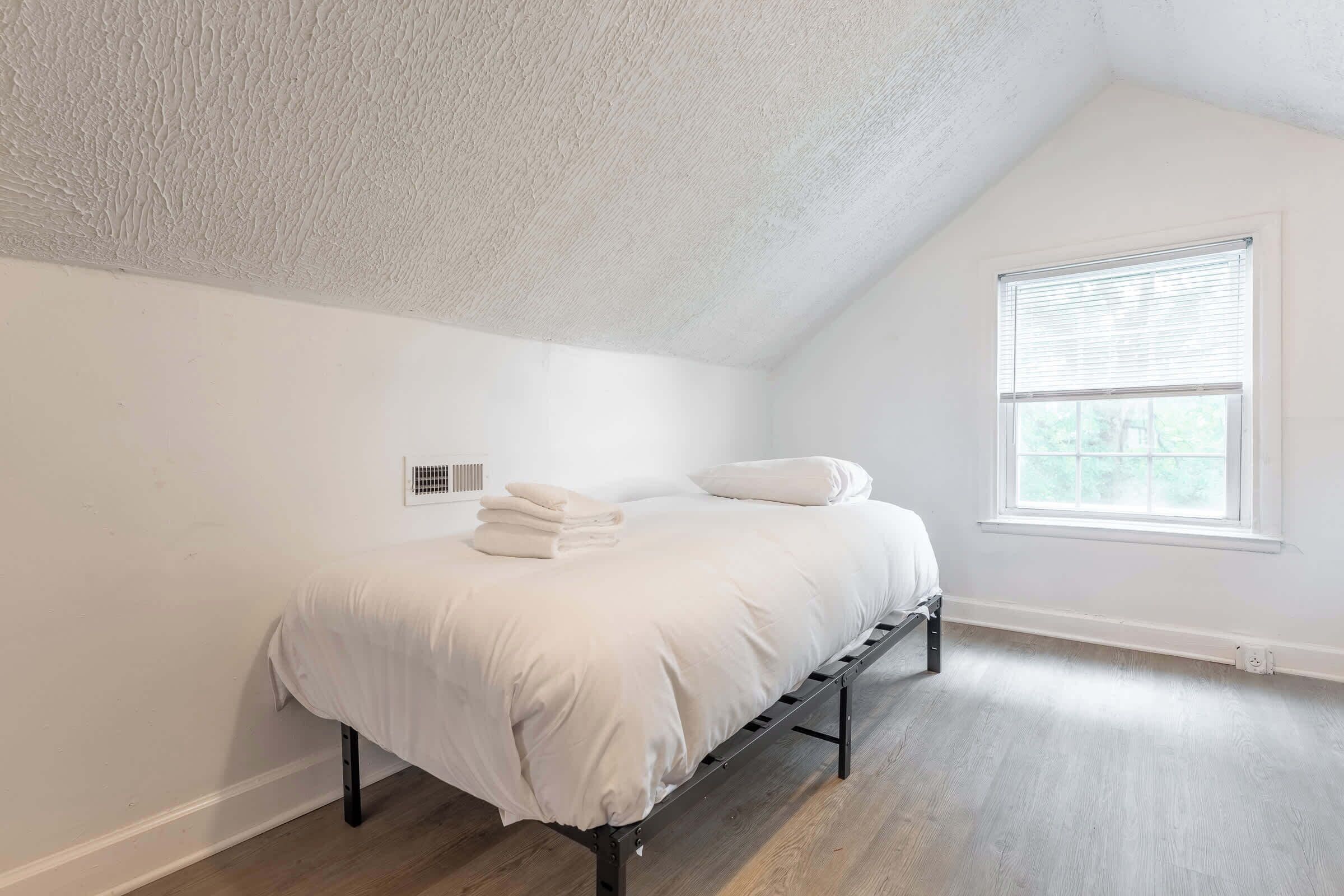 Une chambre à coucher avec un lit, une fenêtre et un radiateur.
