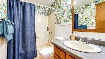 A bathroom with a bathtub, toilet, and sink.