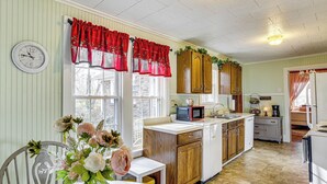 A kitchen with wooden cabinets, a microwave, and a sink.