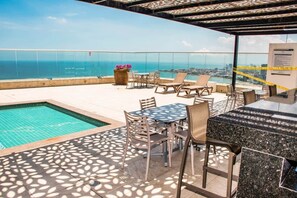 A rooftop bar with a pool, outdoor seating, and a view of the city and ocean. - Super Luxury Beachfront 4BR w/ Ocean view Balcony (Cartagena)