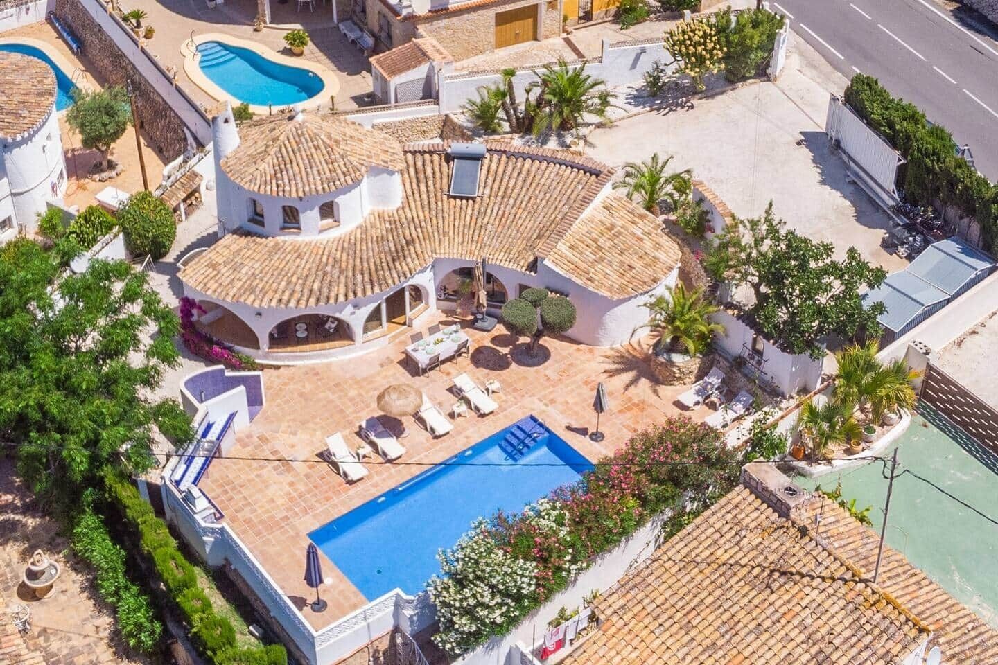 A villa with a swimming pool, outdoor seating, and a garden.