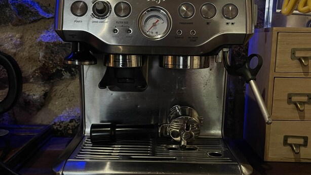 Una máquina de café espresso comercial con perillas de control, una pantalla digital y una boquilla de vapor.