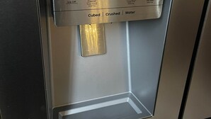 Dispensador de acero inoxidable con opciones de agua, hielo en cubos, hielo picado y un compartimento congelador.