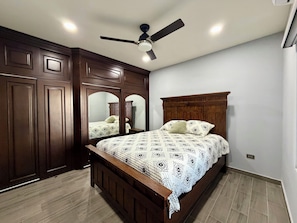 A bedroom with a wooden bed, a ceiling fan, and a large mirror. - Private Beach View Home. Fire Pit. Sleeps 8 (Puerto Peñasco)
