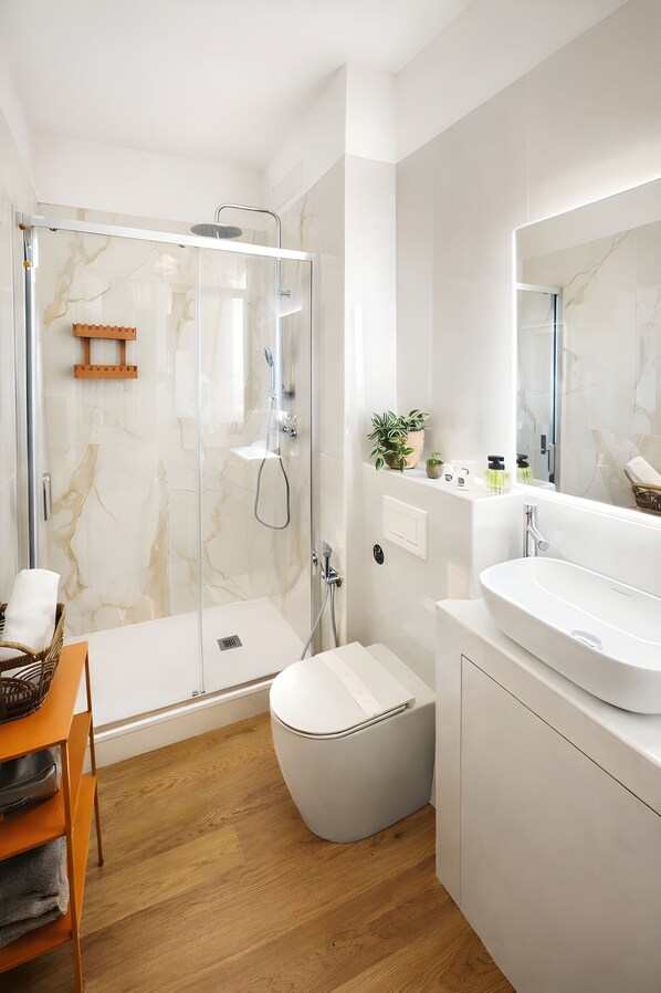 A modern bathroom with a glass-enclosed shower, a white sink, and a large mirror. - Casa Flora Verona (Verona)