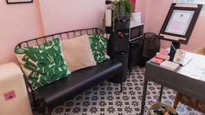 A room with a black metal bench, green patterned pillows, a small desk with a computer, and a tiled floor. - Room 5: Modern City Stay in Santurce (San Juan)
