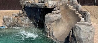 Awesome pool home with rock waterslide, grotto, and waterfall.