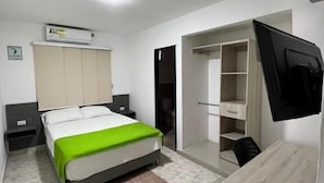 A bedroom with a bed, bedside tables, a TV, a wardrobe, and a desk. - HOTEL Y PISCINA VILLA MARIA URIBIA (Uribia)