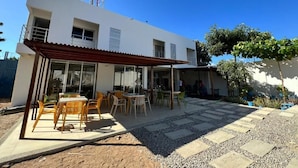 A two-story house with a patio area featuring outdoor furniture. - HOTEL Y PISCINA VILLA MARIA URIBIA (Uribia)