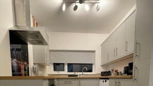 Una cucina moderna con isola centrale, elettrodomestici integrati e un pavimento in legno decorato.