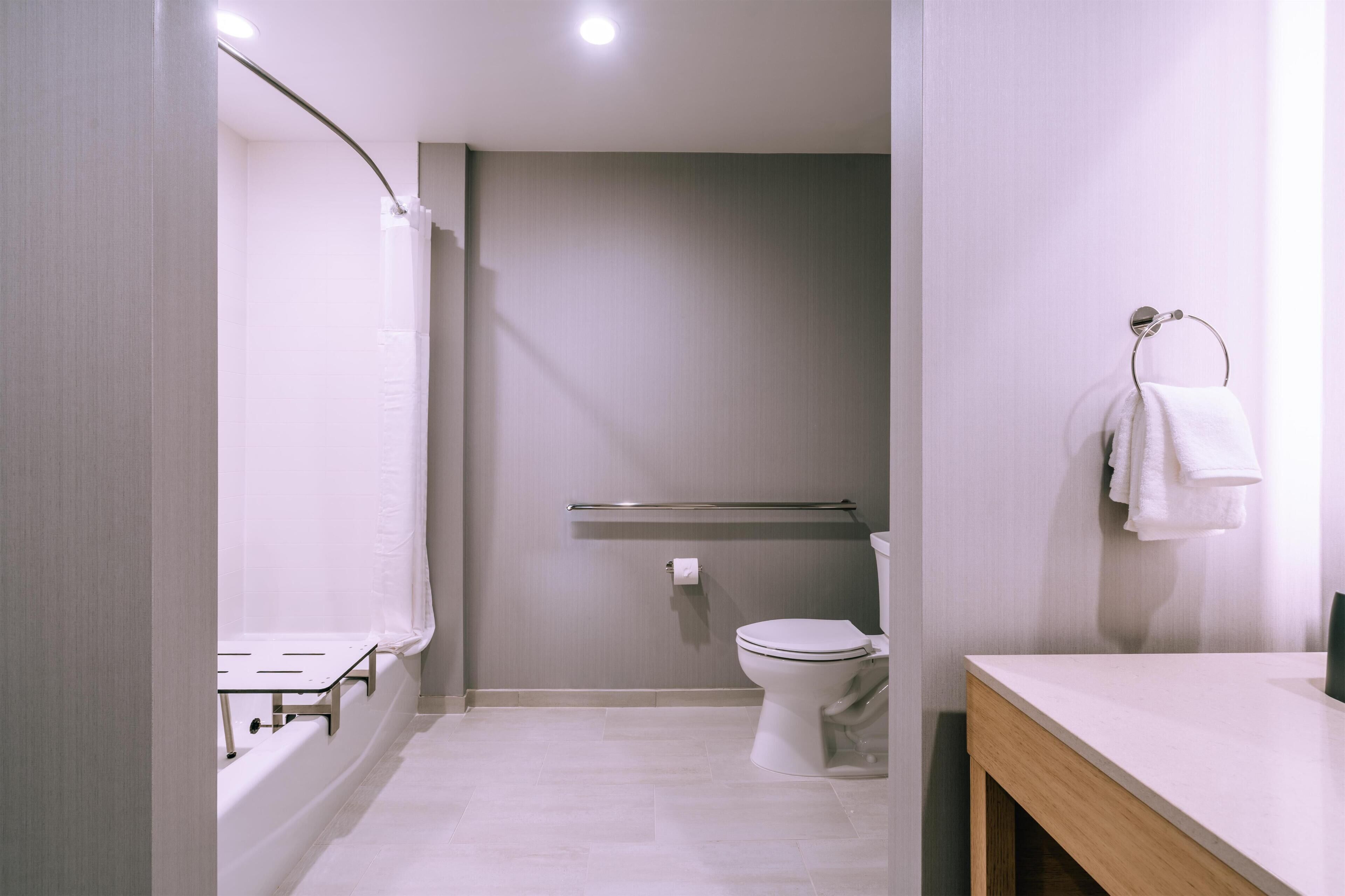Ein modernes Badezimmer mit Toilette, Waschbecken und Duschbereich.