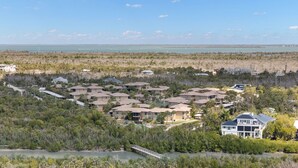 Una zona residenziale costiera con diverse case, un ponte e vista sull'oceano.
