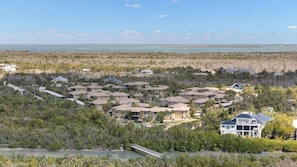A coastal residential area with multiple houses, a bridge, and a view of the ocean. - Gorgeous 2 Story Villa at Blind Pass Condos (Sanibel)