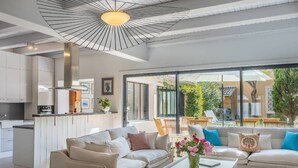 Ein modernes Wohnzimmer mit einer Sofagarnitur, einem Couchtisch mit Blumen und Blick auf die Terrassenanlage.