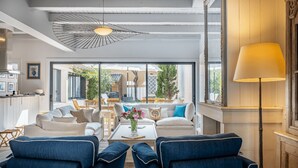 Un salón moderno con un juego de sofá, una mesa de centro con flores y vistas al patio exterior.