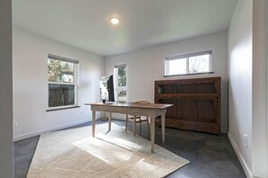 A room with a wooden table, two windows, and a large wooden cabinet. - The Elevation Haus- Modern Rattlesnake Abode (Missoula)