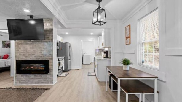 A modern kitchen with a built-in fireplace, white cabinetry, and a dining area with a wooden table and bench. - Charming 3-bedroom house with WiFi and AC in marvelous Atlanta (Atlanta)