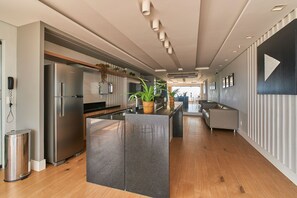 Eine moderne Küche mit einer zentralen Kochinsel, Edelstahlgeräten und Holzböden.