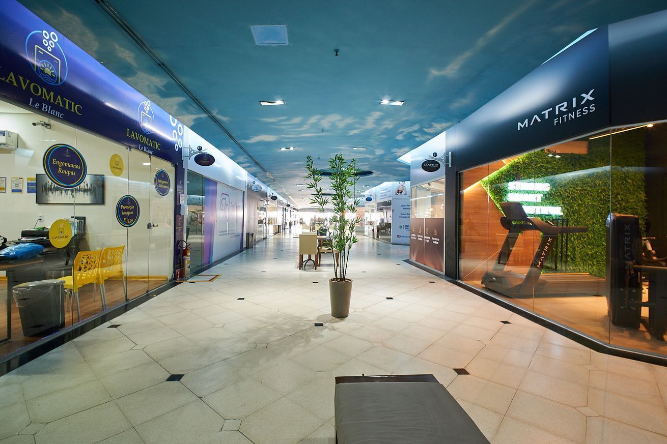 A corridor with shops on either side, including a Matrix Fitness store.