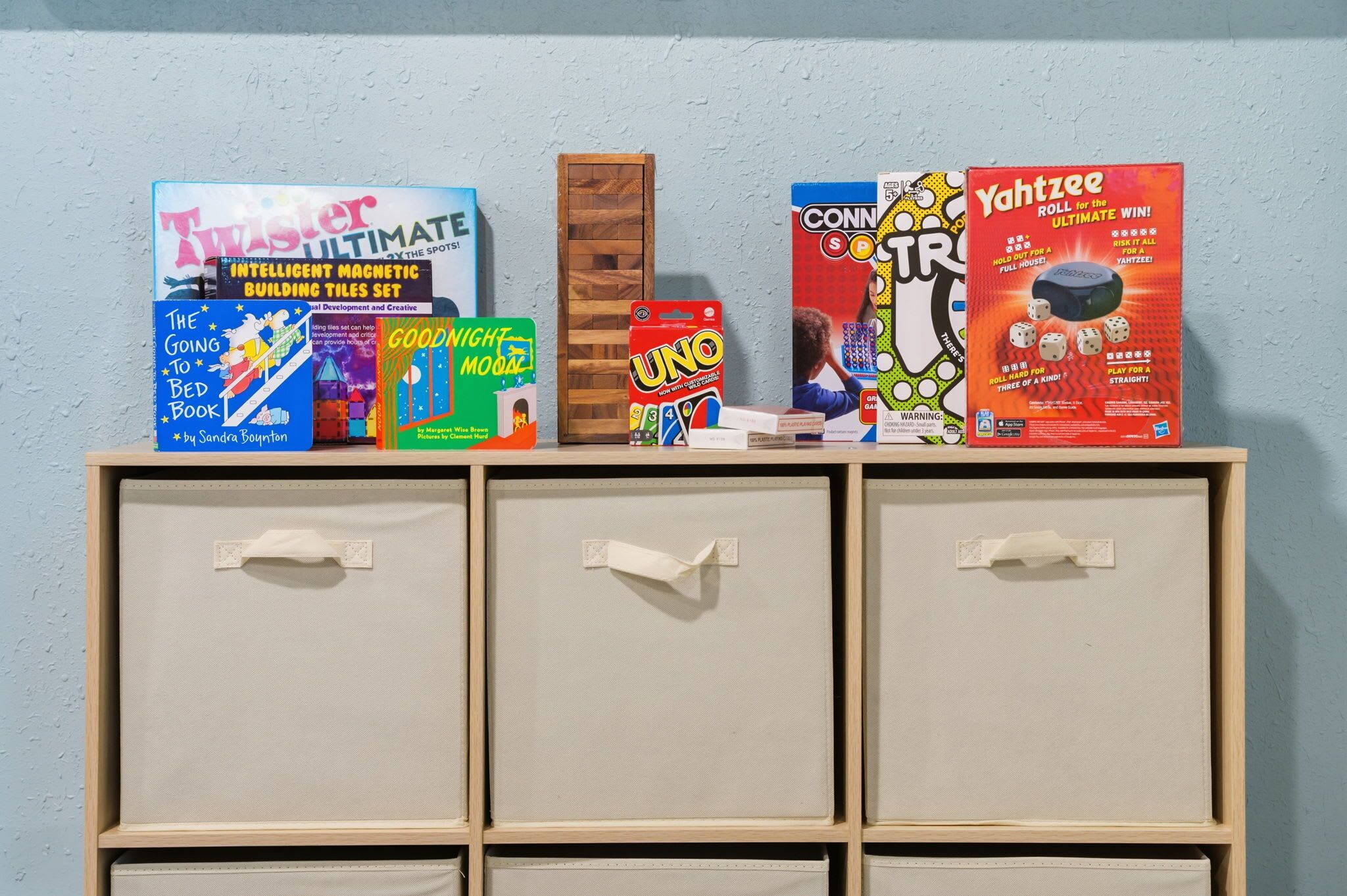 A shelf with various board games and a wooden box.