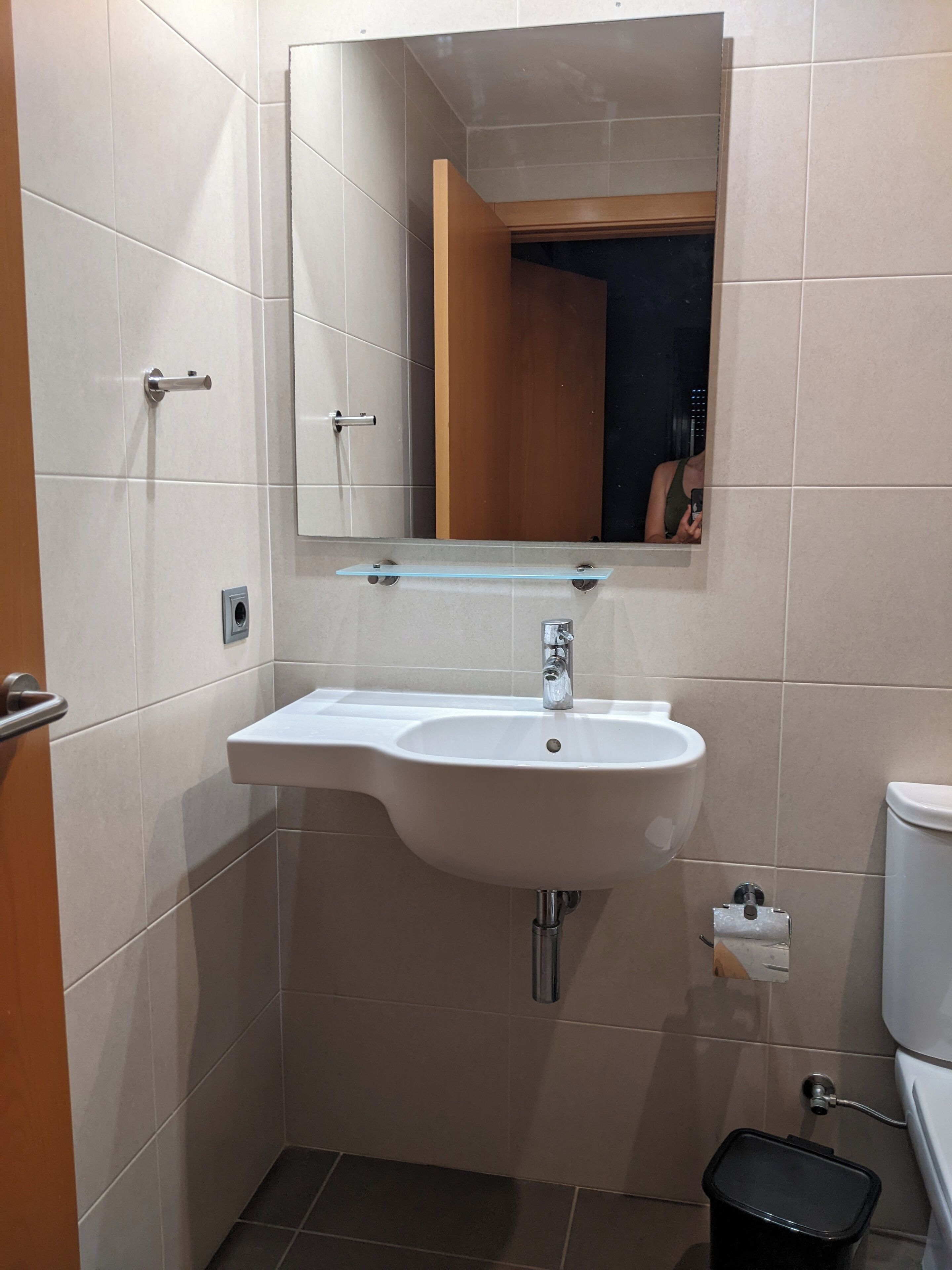 Ein Badezimmer mit Waschbecken, Spiegel und Toilette.