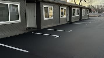 Une rangée de bâtiments d’un seul étage, avec un parking devant.